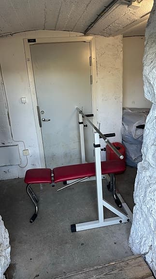 Träningsbänk med skivstång och vikter