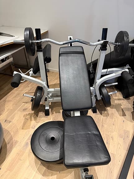 Träningsbänk med skivstång och vikter