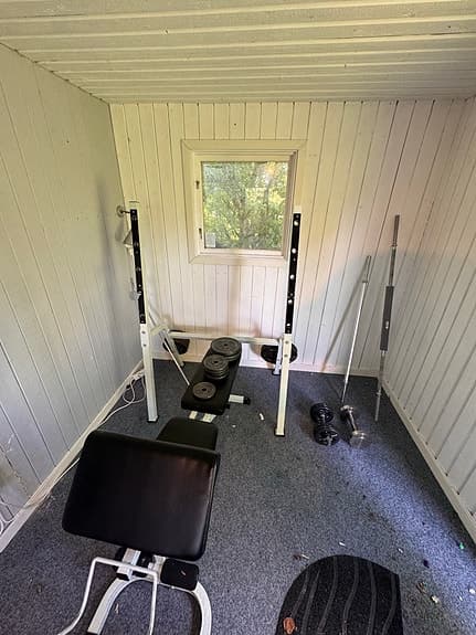 Träningsbänk med skivstång och vikter