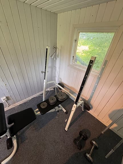 Träningsbänk med skivstång och vikter