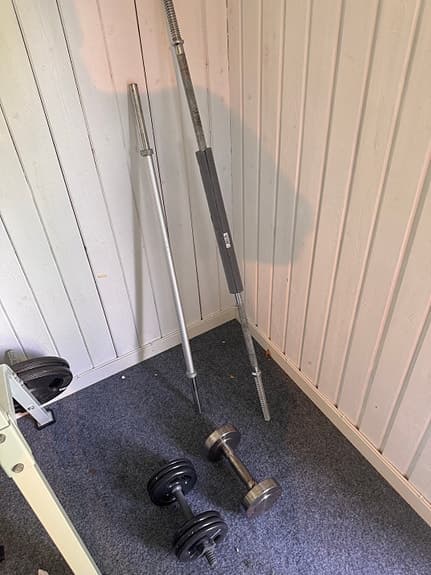 Träningsbänk med skivstång och vikter