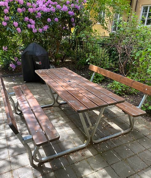 Trädgårdsbord med fasta bänkar i trä och metall säljes. 2 stycken.