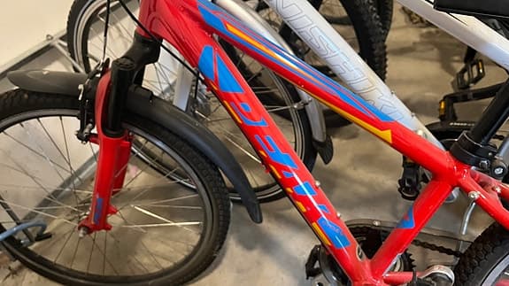 Röd barncykel med blå text