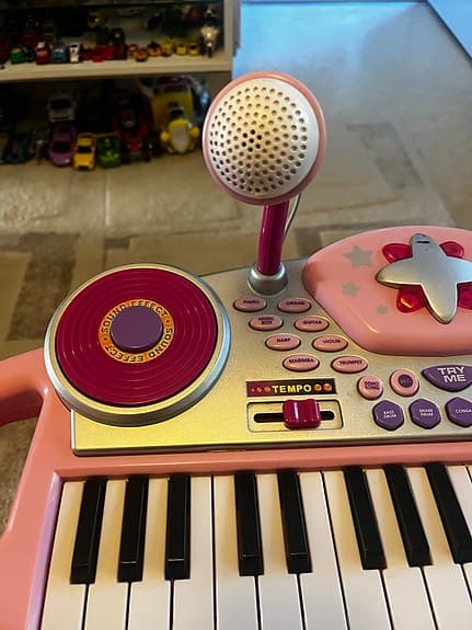 Rosa leksakspiano med mikrofon och pall