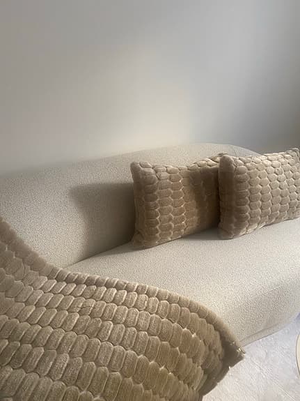 beige pläd och kuddar med strukturmönster