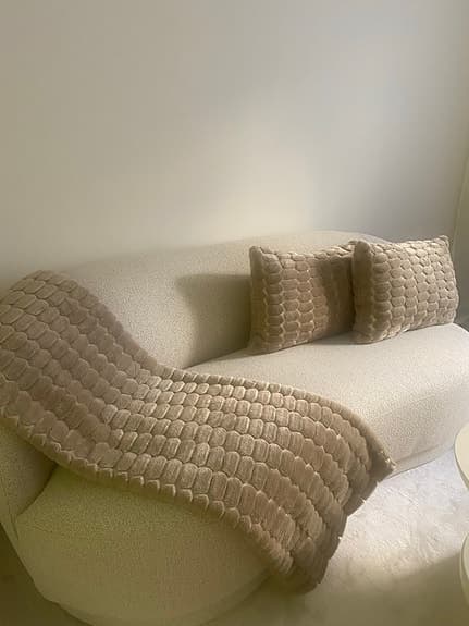 beige pläd och kuddar med strukturmönster
