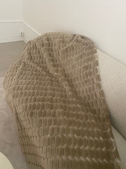 beige pläd och kuddar med strukturmönster