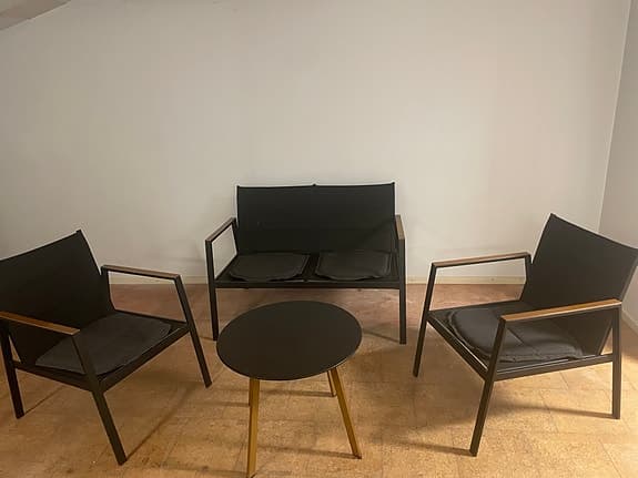 Svart sittgrupp med två fåtöljer, soffa och bord