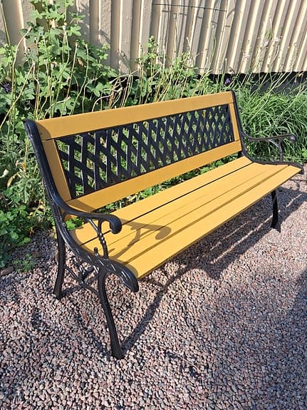 Vacker ockragul parkbänk, trädgårdsbänk