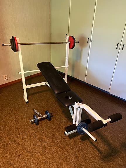 Träningsbänk med skivstång och vikter