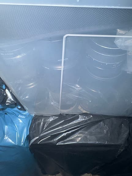 Låda med blandade kameratillbehör och objektiv