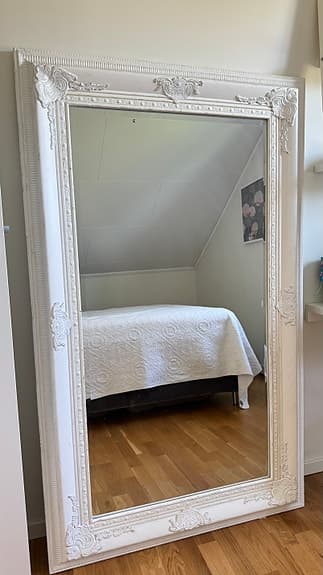 Elegant barockspegel med vit ornamenterad ram.