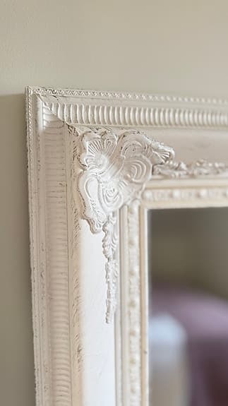 Elegant barockspegel med vit ornamenterad ram.