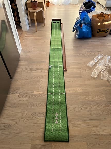 Golf puttingmatta inomhus med två hål grön