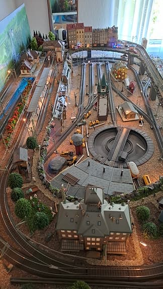 Modelltåg Märklin tågbana med landskap och hus