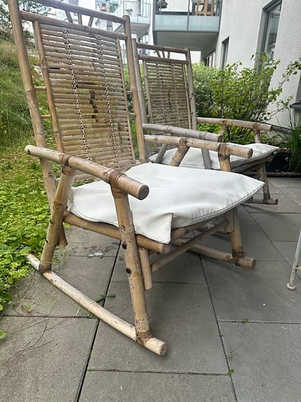 Två charmiga bambu-gungstolar med dynor