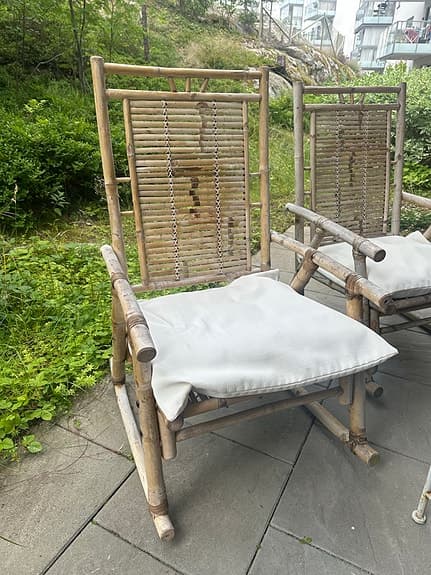 Två charmiga bambu-gungstolar med dynor