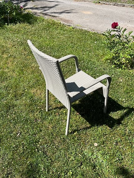 Beige konstrotting trädgårdsstol med armstöd samt dyna