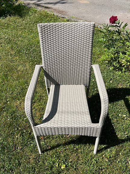 Beige konstrotting trädgårdsstol med armstöd samt dyna
