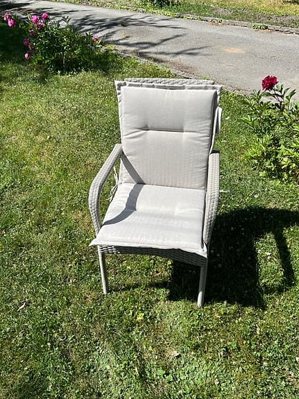 Beige konstrotting trädgårdsstol med armstöd samt dyna