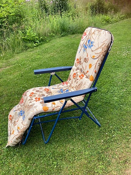 Blå fällbar solstol med blommig dyna retro