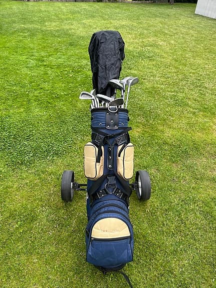 Golfset med vagn, bag, klubbor och bollar.