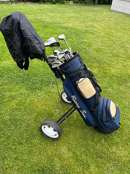 Golfset med vagn, bag, klubbor och bollar.