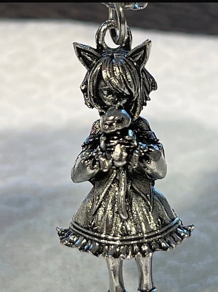 Hänge med figur i metall, kedja ingår