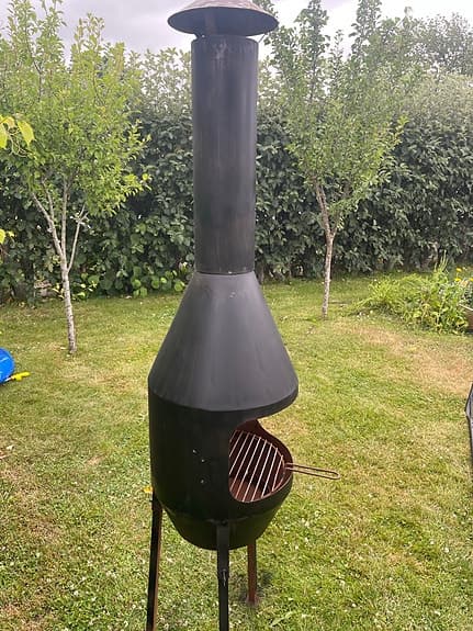 Svart utebrasa med skorsten och grillgaller