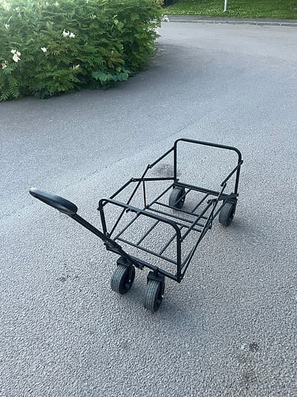 Svart vagn med handtag och fyra hjul