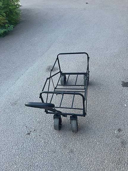 Svart vagn med handtag och fyra hjul