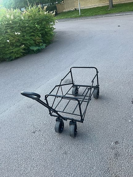 Svart vagn med handtag och fyra hjul