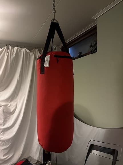Röd boxningssäck med upphängning