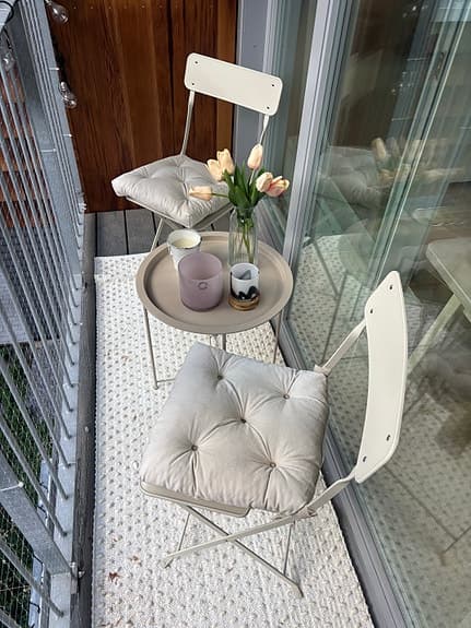 Balkongset med två stolar och runt bord beiget