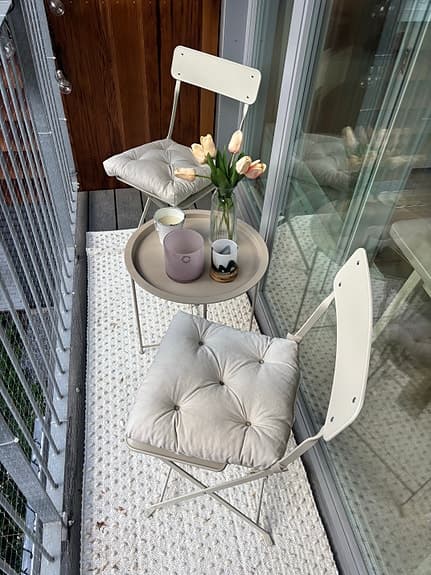 Balkongset med två stolar och runt bord beiget