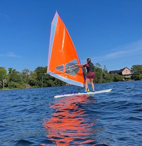 Vindsurfingbräda med orange segel
