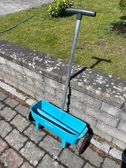 Blå gödselspridare för gräsmatta