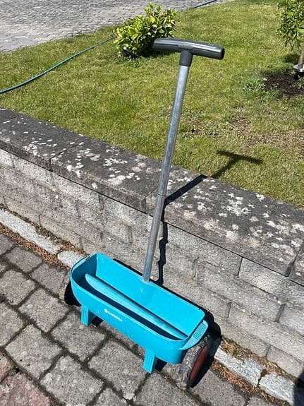 Blå gödselspridare för gräsmatta