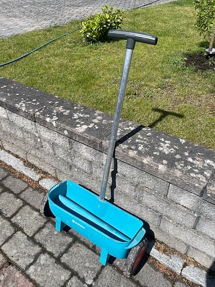 Blå gödselspridare för gräsmatta