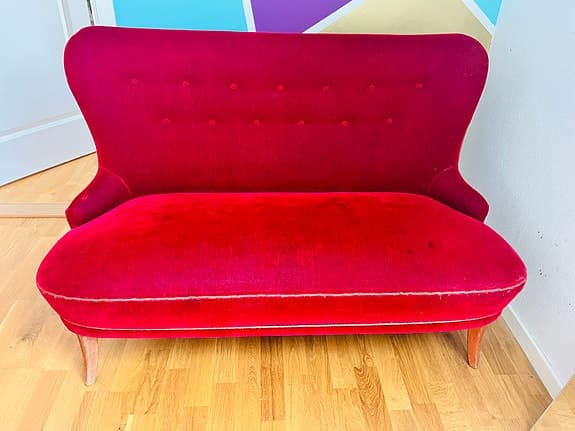 Fin mindre soffa i röd velour klädsel.