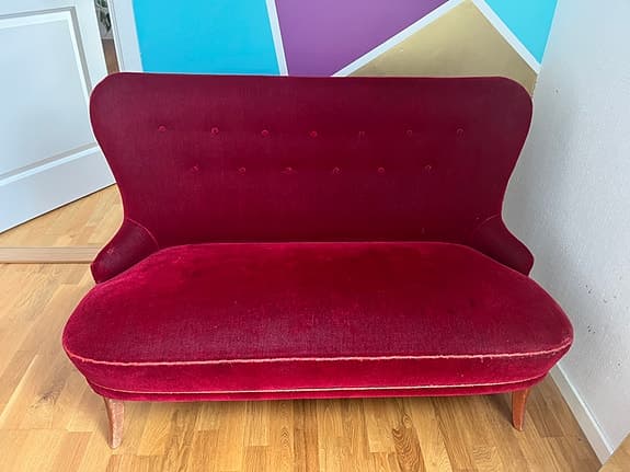 Fin mindre soffa i röd velour klädsel.