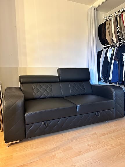 Svart bäddsoffa med justerbara nackstöd