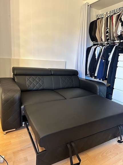 Svart bäddsoffa med justerbara nackstöd