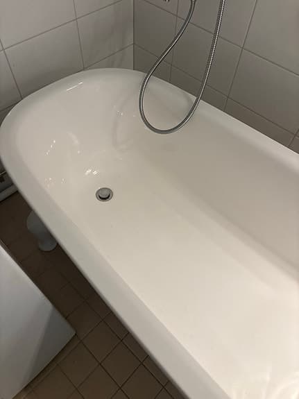 Vitt fristående badkar på fötter