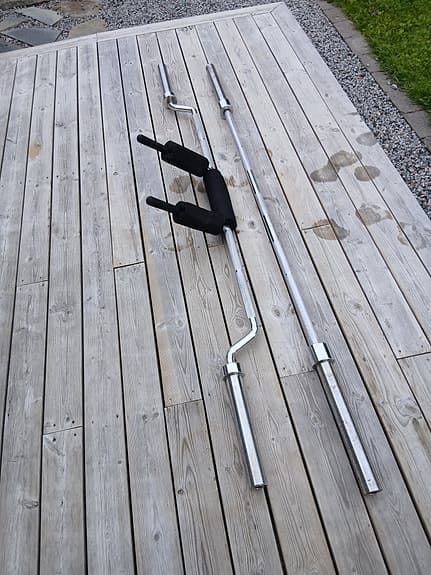 Träningsbänk med skivstänger och vikter