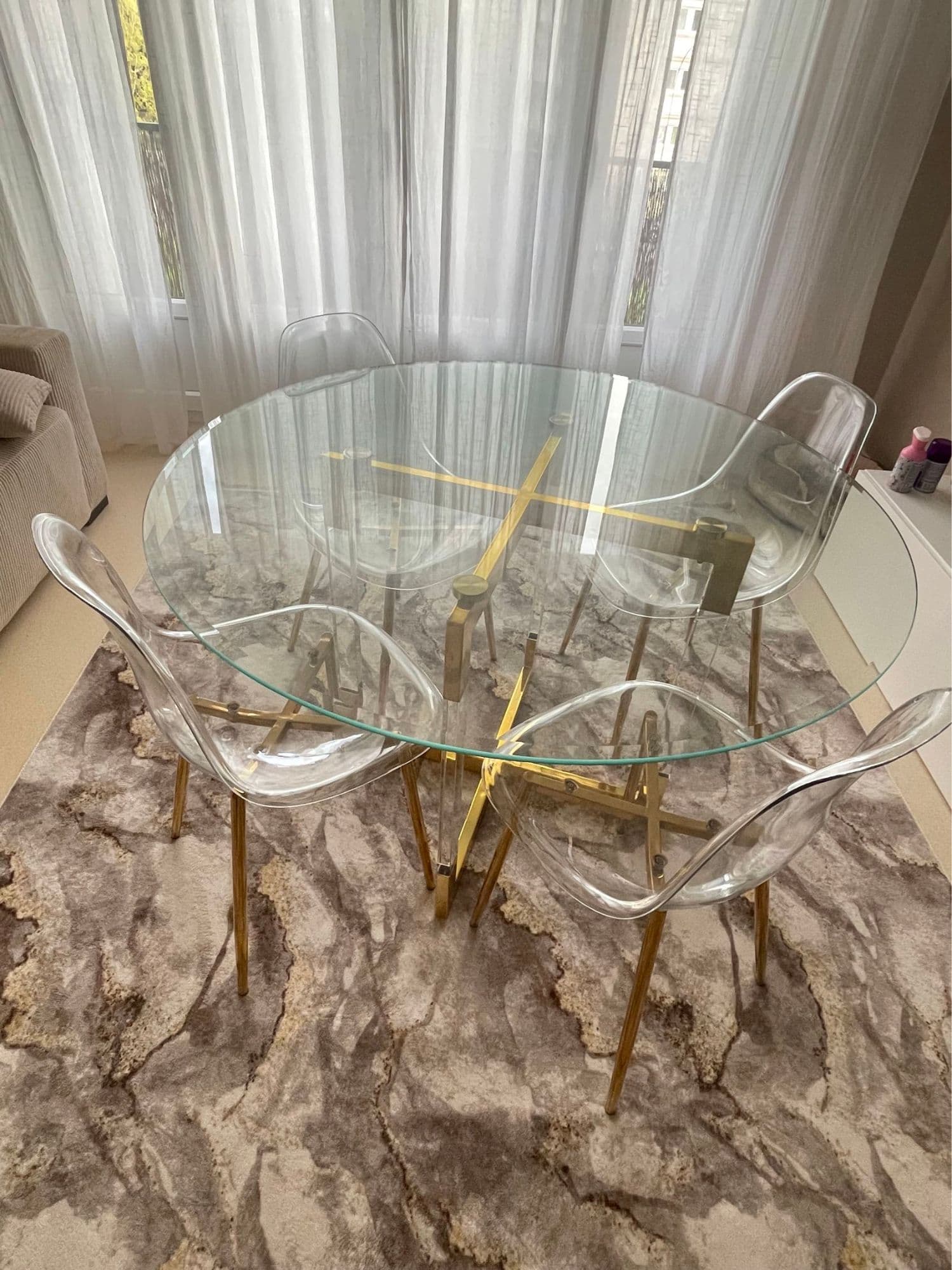 Table en verre ronde doré avec quatre chaises, une table basse carré et une console assorties..