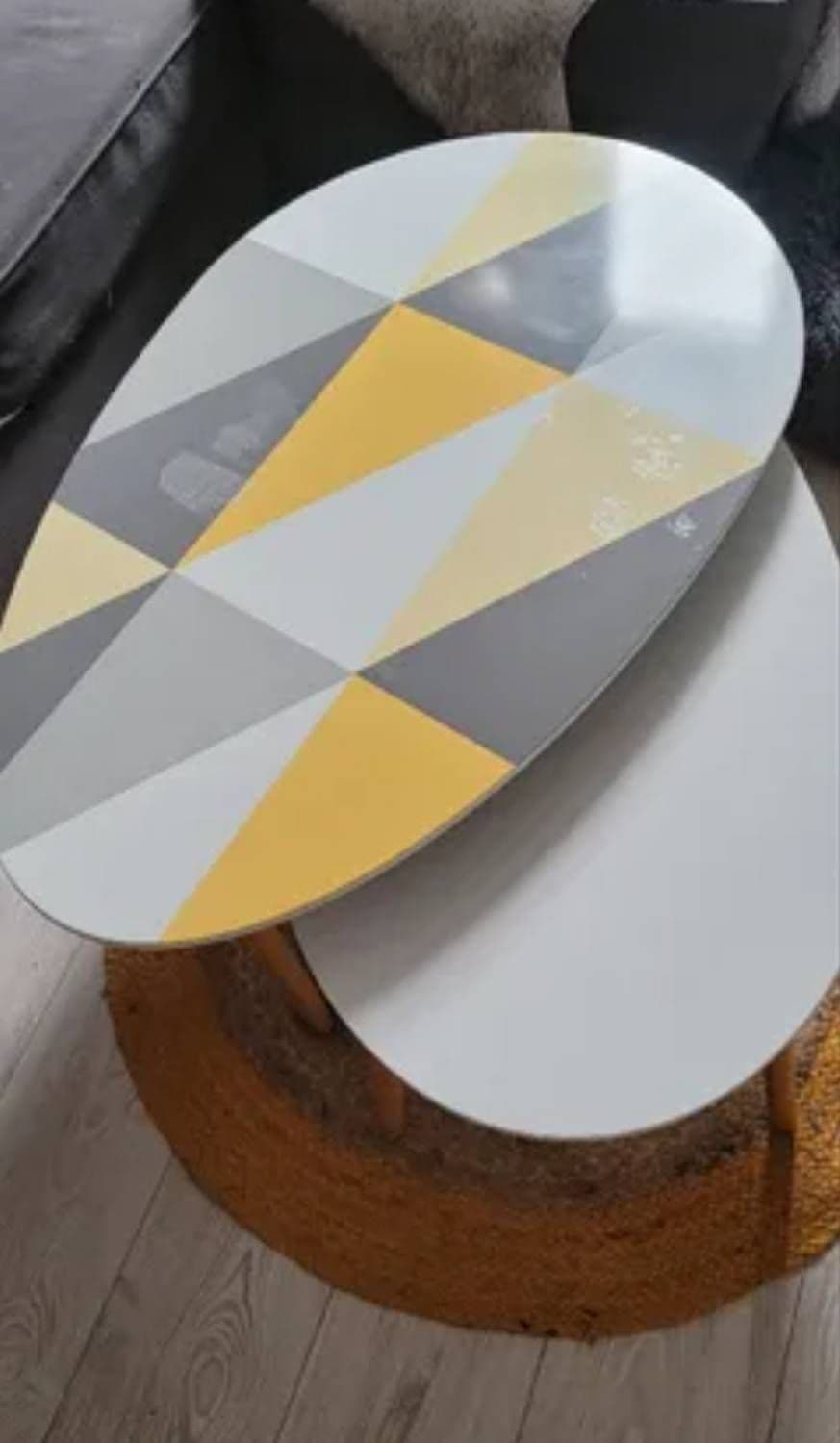 Gigognes Au Design Contemporain. La Plus Grande Table Présente Un Plateau Ovale Avec Un Motif Géométrique Élégant En Jaune, Gris Et Blanc. La Plus Petite Table Est Entièrement Blanche, Avec Un Plateau