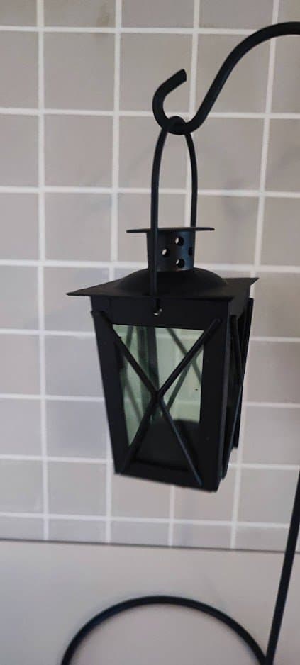 Svart smideslykta på fot. För värmeljus