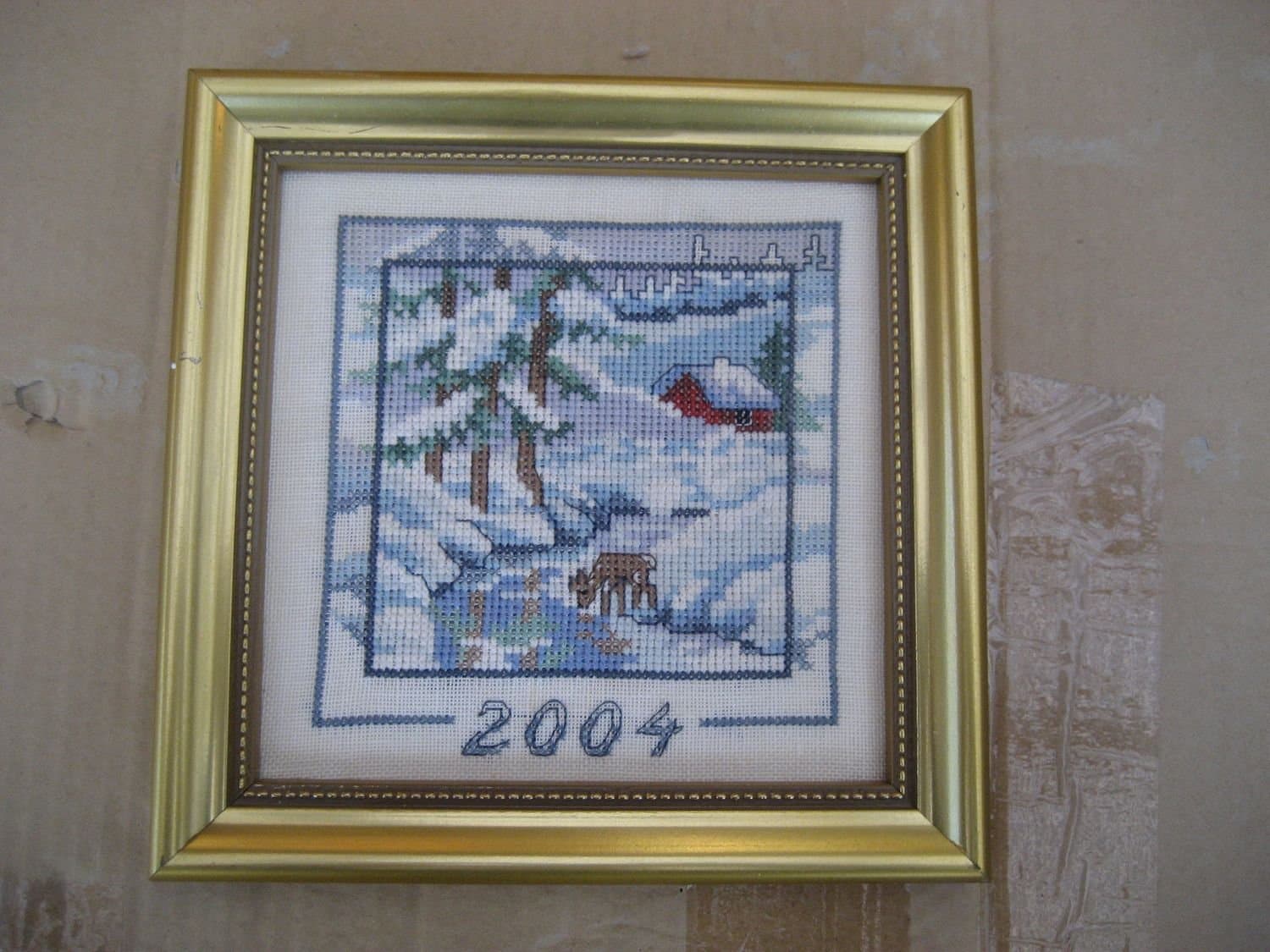 Tavla handsydd med motiv på hus & rådjur i vinterlandskap - Årstavla 2004