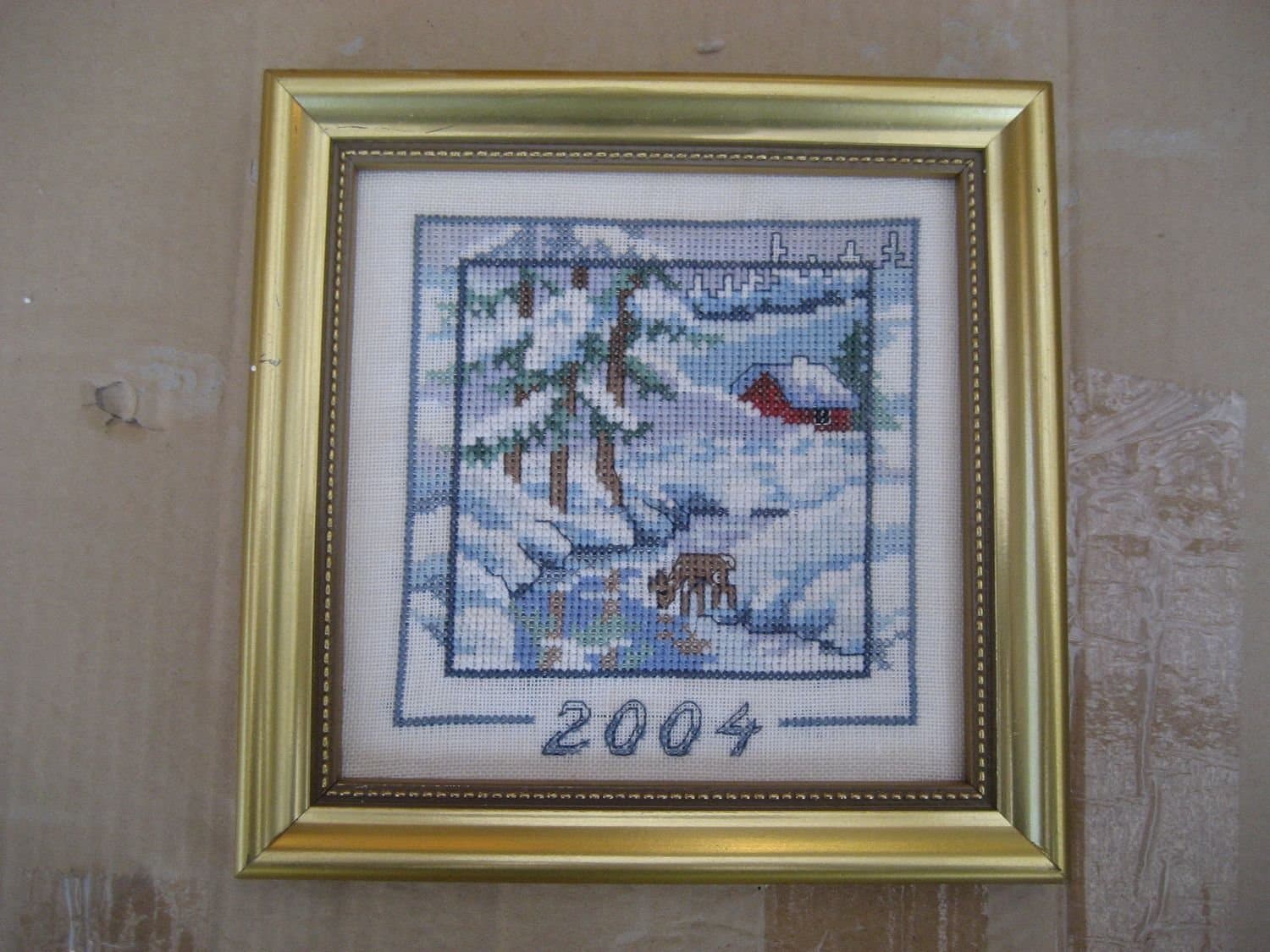 Tavla handsydd med motiv på hus & rådjur i vinterlandskap - Årstavla 2004